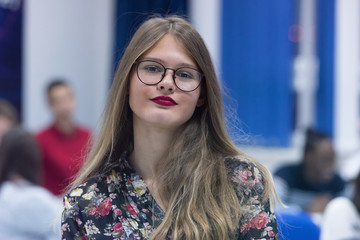 Obraz premium Students life on the campus.Portrait of female college student smiling and looking at camera during class in the classroom.