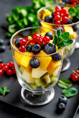 Fresh salad with fruits and berries in glass.