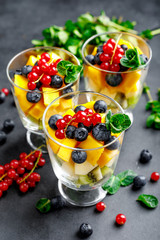 Fresh salad with fruits and berries in glass.