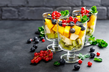 Fresh salad with fruits and berries in glass.
