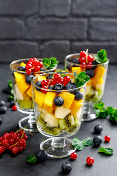 Fresh salad with fruits and berries in glass.