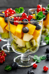 Fresh salad with fruits and berries in glass.