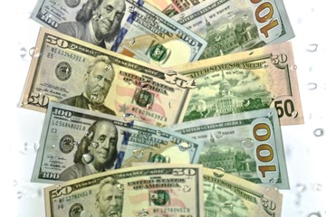 Dollars covered with a small amount of water droplets, lined track overlap in the center.