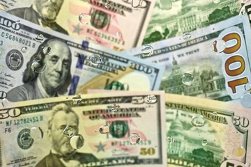 American dollars, in drops of water, laid obliquely overlapped. On the whole frame.