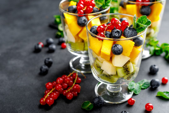 Fresh salad with fruits and berries in glass.