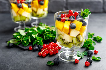 Fresh salad with fruits and berries in glass.