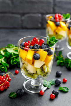 Fresh salad with fruits and berries in glass.