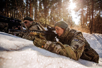 team of special forces weapons in cold forest. Winter warfare and military concept - obrazy, fototapety, plakaty
