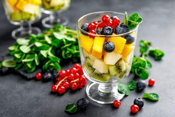 Fresh salad with fruits and berries in glass.