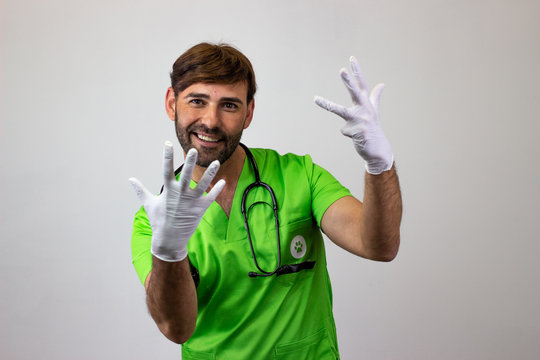 Portrait of male veterinary doctor in green uniform with brown hair holding up nine fingers, looking at the camera. Isolated on white background.