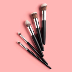 Creative concept beauty fashion photo of cosmetic product make up brushes kit on pink background.