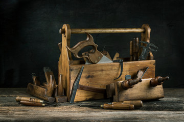 Still life - Old Wooden vintage toolbox with hammers, saw, chisels, plane and pliers in carpentry