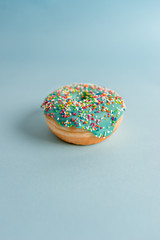  donut with colorful sprinkles on blue background