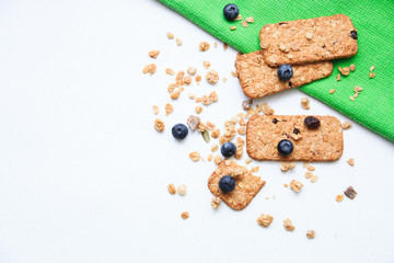 Crunchy muesli cookies and blueberries on green napkin, Breakfast cereals isolated on white background, selective focus, top view