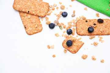 Crunchy muesli cookies and blueberries on green napkin, Breakfast cereals isolated on white background, selective focus, top view