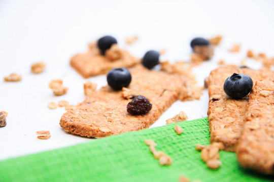 Crunchy muesli cookies and blueberries on green napkin, Breakfast cereals isolated on white background, selective focus, top view