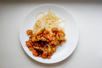 Macaroni with vegetables on a white plate