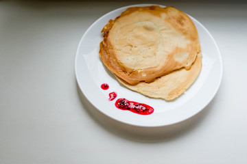 Pancakes with jam on a white plate