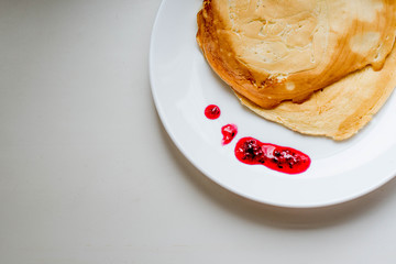 Pancakes with jam on a white plate