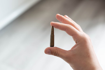 A cartridge from a Kalashnikov machine in his hand