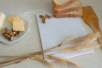 We cook breakfast. In the photo: flour, eggs, bread, cheese, notebook, olive oil, butter and wheat sprouts