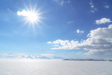 Obraz premium frozen lake with surrounding snow covered rocky mountains 