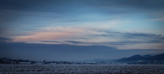 blue hour panorama in the winter on a snowy field on a cold day in winter