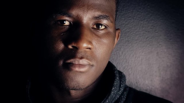 Pensive confident young american african man in dark,turning and looking camera