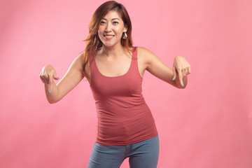 Beautiful young Asian woman point down to blank space.