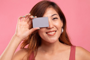 Young Asian woman with  blank card over her eye.