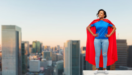 super power and people concept - happy african american young woman in superhero red cape on roof top over sunrise in tokyo city background © Syda Productions