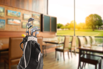 Golf bag  and golf clubs  of golfer have breakfast in club house restaurants at golf course. Before...