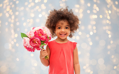 childhood and people concept - happy little african american girl with flowers over festive lights background