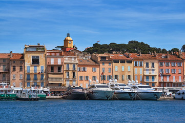 Sailboats and yachts moored to the quay port of Saint-Tropez, France.