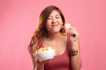 Young Asian woman eat potato chips.