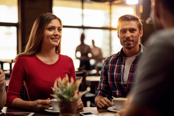Young happy couple spending time with friends in a cafe.
