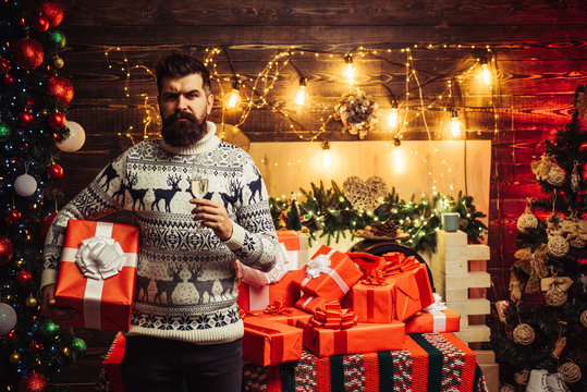 Delivery gifts. New year gift. Styling man with a long beard posing on the wooden background. Portrait of a brutal mature Santa Claus.