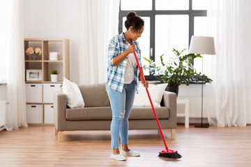 people, housework and housekeeping concept - happy african american woman or housewife with...