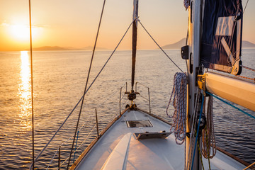 Sailing boat in the sea during awesome sunset.