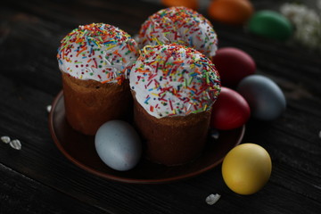 Traditional easter cake kulich Ukrainian Russian style with colored eggs on wooden background