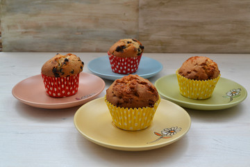 Vanilla cupcakes with chocolate on colorful plates
