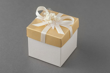 Gift box with bow on gray background.