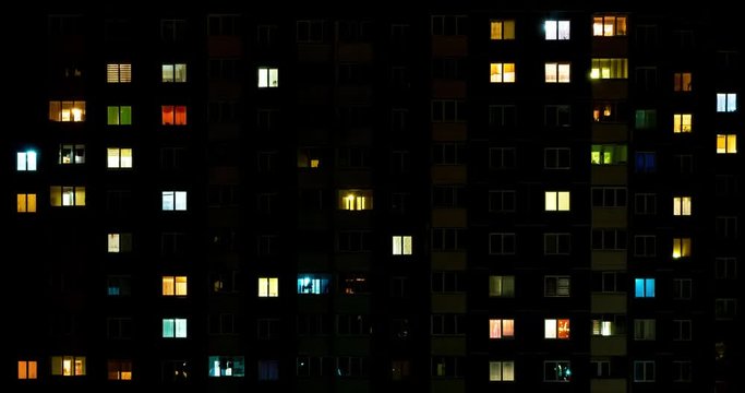 Night time lapse of Light in the windows of a multistory building. life in a big city