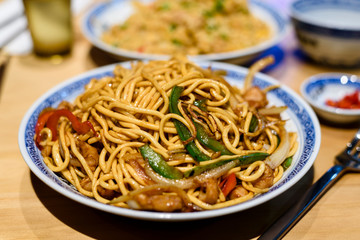 Singapore Chinese fried noodles with chicken and vegetables in a plate.