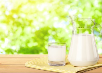 Glass of milk and jar on table