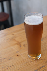 Portrait View of Tall Cold Beer Glass on Wood Table
