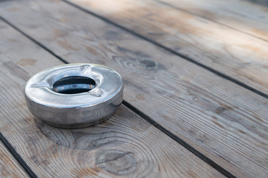 Close up View of Metal Ashtray on Wooden Table During the Daytime