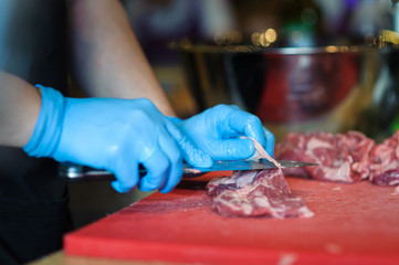 man's hands cutting meat