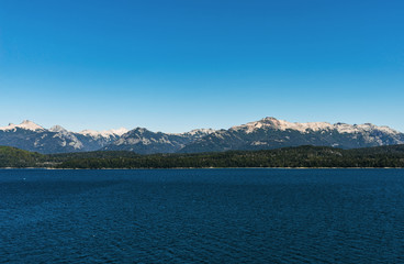 Scenic aerial nature colorful landscape photo of blue aquamarine lakes, rivers, Andes mountains, and green tree forest in Patagonia, Argentina