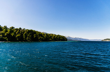 Fototapeta premium Scenic aerial nature colorful landscape photo of blue aquamarine lakes, rivers, Andes mountains, and green tree forest in Patagonia, Argentina